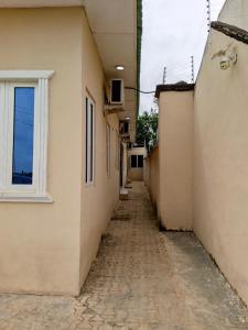 un callejón entre dos edificios con ventana en F&B Service Apartment en Abeokuta