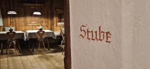 a dining room with a table and chairs and a sign at Ansitz Heufler in Rasun di Sopra