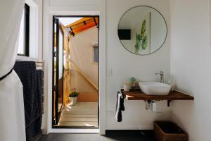 a bathroom with a sink and a mirror at Villas & Vines Glamping in Hastings