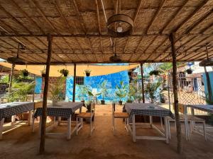 een groep tafels en stoelen onder een tent bij North & East Arambol I Goa in Arambol