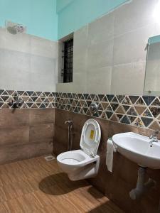 a bathroom with a toilet and a sink at North & East Arambol I Goa in Arambol