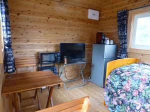 a bedroom with a bed and a refrigerator and a table at こや・かやき in Yufu