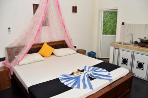 a bedroom with a bed with a pink and blue canopy at Kosi Giggles Resort in Weligama