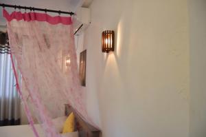 a bedroom with a pink curtain on a wall at Kosi Giggles Resort in Weligama