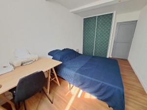 1 dormitorio con 1 cama y escritorio con teléfono en L'Ostal, en Carcassonne