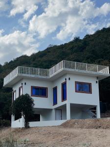 ein weißes Haus mit Balkon darüber in der Unterkunft deep mountain view in Ko Larn