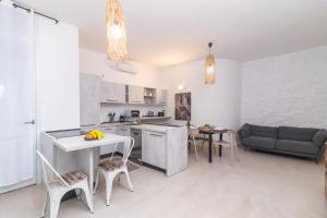 Una cocina y una sala de estar con mesa y sillas. en Secret Garden House - Happy Rentals, en Marina di Portisco
