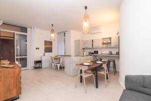 Una cocina y una sala de estar con mesa y sillas. en Secret Garden House - Happy Rentals, en Marina di Portisco