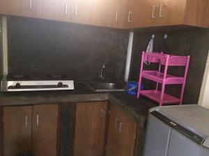 een keuken met een roze kruk en een wastafel bij Simple apartment 1 in Seminyak