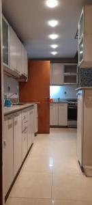 cocina grande con armarios y electrodomésticos blancos en DEPARTAMENTO ABASTO en Buenos Aires