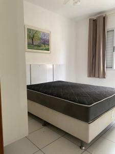 a bed in a room with a black mattress at Apartamento Aconchegante Sun Way in Ubatuba