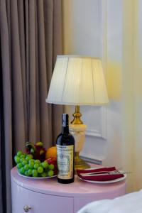 a bottle of wine sitting on a table with a lamp at Le Haute Hotel Hai Phong in Hai Phong