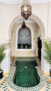 una piscina in un edificio con lampadario pendente di Riad Al Mamoune a Marrakech