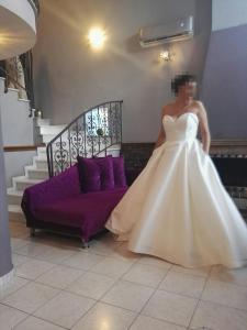 a woman in a wedding dress standing next to a couch at Dana's Luxury Maisonette in Volos