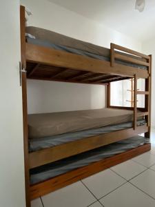 a couple of bunk beds in a room at Apartamento Aconchegante Sun Way in Ubatuba