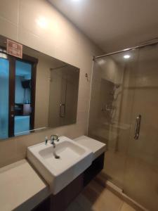 ein Bad mit einem Waschbecken und einer Dusche in der Unterkunft Votel Viure Hotel Jogjakarta in Yogyakarta