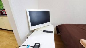 a computer monitor on a table with a remote control at 札幌市中心部大通公園まで徒歩八分観光移動に便利なロケーションe1007#17 in Sapporo
