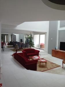 a living room with red furniture and a christmas tree at ΠΟΛΥΤΕΛΗΣ ΒΙΛΑ 8 - 10 ΑΤΟΜΩΝ ΣΤΗΝ ΠΕΡΙΟΧΗ ΑΕΡΟΔΡΟΜΙΟΥ ΘΕΣΣΑΛΟΝΙΚΗΣ in Livadákion