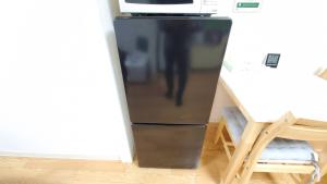a black refrigerator in a room with a table at 札幌市中心部大通公園まで徒歩八分観光移動に便利なロケーションe1007#17 in Sapporo
