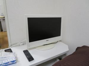 a computer monitor sitting on a desk with a remote control at 札幌市中心部大通公園まで徒歩八分観光移動に便利なロケーションe1007#17 in Sapporo