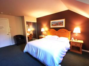 pokój hotelowy z dużym łóżkiem i 2 lampami w obiekcie Hotel Alila w mieście Saint-Sauveur-des-Monts