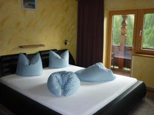 Un dormitorio con una cama con almohadas azules. en Kreidl, en Tux