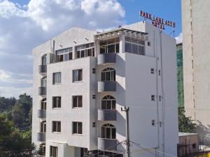 Un bâtiment blanc avec un panneau en haut dans l'établissement Park Lane Addis Hotel, à Addis-Abeba