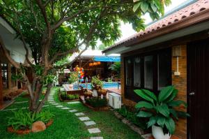 a yard with a house with a tree and a patio at Amit Resort 51 Hua Hin in Hua Hin