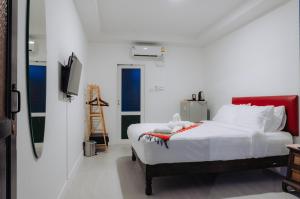 a white bedroom with a bed and a tv at Amit Resort 51 Hua Hin in Hua Hin