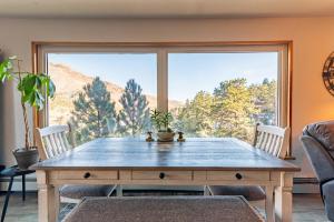 a dining room with a table and a large window at Winnemucca Heights in Cascade-Chipita Park