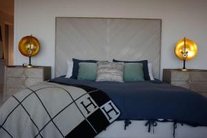 Skyline Serenity Luxe Suite-Private Room في لوس أنجلوس: غرفة نوم بسرير لحاف ازرق ومصباحين