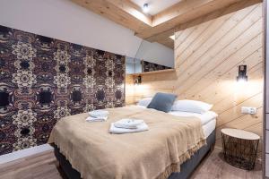 a bedroom with a bed with towels on it at Willa Trawers in Zakopane
