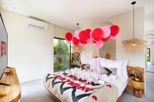 a bedroom with a bed with red balloons on it at Suara Alam Hotel Ubud by Ini Vie Hospitality in Ubud