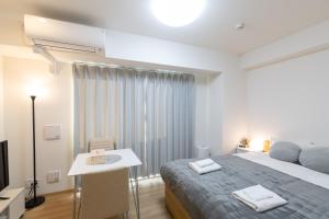 a bedroom with a bed and a table and a television at エイビル Ei building in Osaka +37 photos