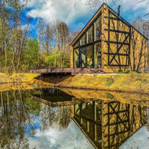 eine Brücke über einen Fluss mit seiner Reflexion im Wasser in der Unterkunft Siedlisko Kamionka in Kamionka