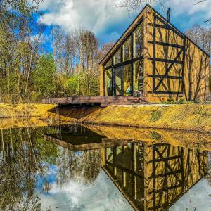 a bridge over a river with its reflection in the water at Siedlisko Kamionka in Kamionka