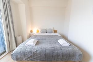 大阪的住宿－エイビル，一间卧室配有一张大床和两条毛巾