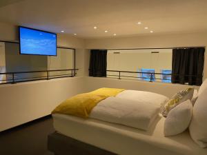 1 dormitorio con 1 cama y TV de pantalla plana en Loft im Turm, en Maishofen