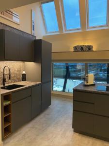 a kitchen with gray cabinets and a large window at Loft im Turm in Maishofen