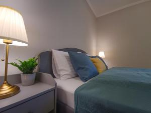 a bedroom with a bed with pillows and a lamp at F151 Elitehost Futó Apartment in Budapest