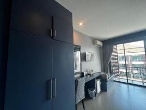 a kitchen with blue cabinets and a large window at Srisawara Casa Hotel in Krabi town