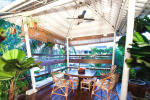 a table and chairs on a balcony with a ceiling fan at OYO 90855 Vince Villa in Bukit Mertajam