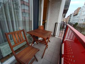 two chairs and a wooden table on a balcony at F151 Elitehost Futó Apartment in Budapest