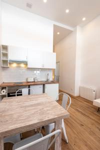 a kitchen with a wooden table and white cabinets at Madrid centro, cálido nuevo, wifi, lava y secarropas in Madrid