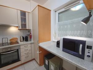 a kitchen with a counter with a microwave and a window at F151 Elitehost Futó Apartment in Budapest