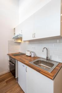 a kitchen with white cabinets and a sink at Madrid centro, cálido nuevo, wifi, lava y secarropas in Madrid