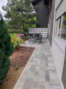 a patio with a table and bench on the side of a house at Emmerich`s Ferienwohnung in Frebershausen +9 photos