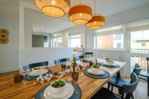 a dining room with a table and chairs and lights at Coastguards in Aldeburgh