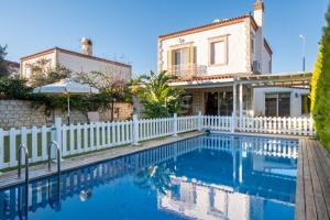 a house with a white fence and a swimming pool at Luxury Duplex Villa w Pool and Garden in Alacati in Alacati