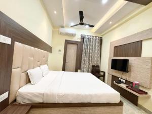 um quarto com uma cama grande e uma televisão em Hotel Nandini Palace ! Varanasi ! ! fully-Air-Conditioned-hotel family-friendly-hotel, near-Kashi-Vishwanath-Temple and Ganga ghat em Varanasi